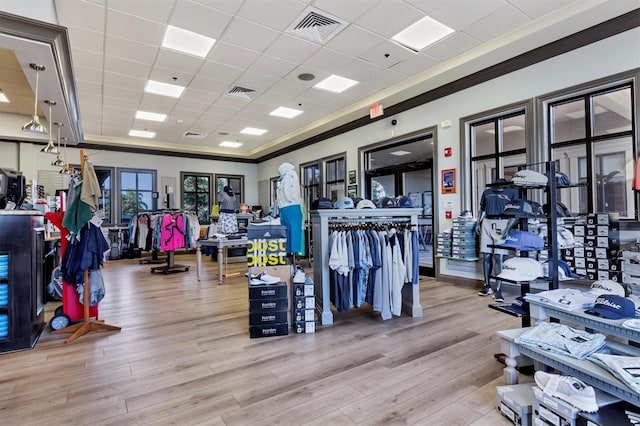 workout area featuring crown molding, a drop ceiling, wood finished floors, and visible vents