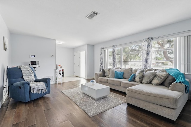 living room featuring baseboards, visible vents, and dark wood-style floors
