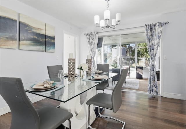 dining room featuring baseboards, wood finished floors, and a notable chandelier