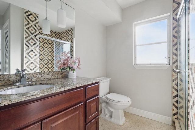 full bathroom with vanity, toilet, baseboards, speckled floor, and a stall shower