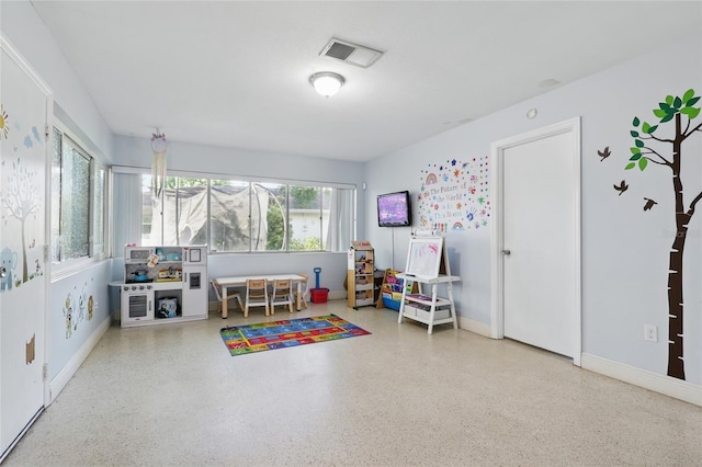 rec room featuring baseboards, speckled floor, and visible vents