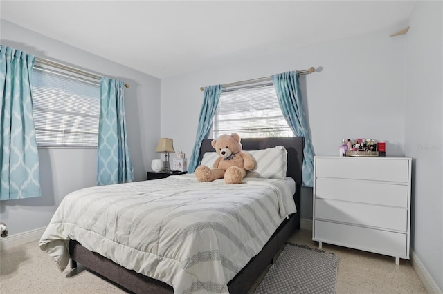 bedroom with baseboards and speckled floor