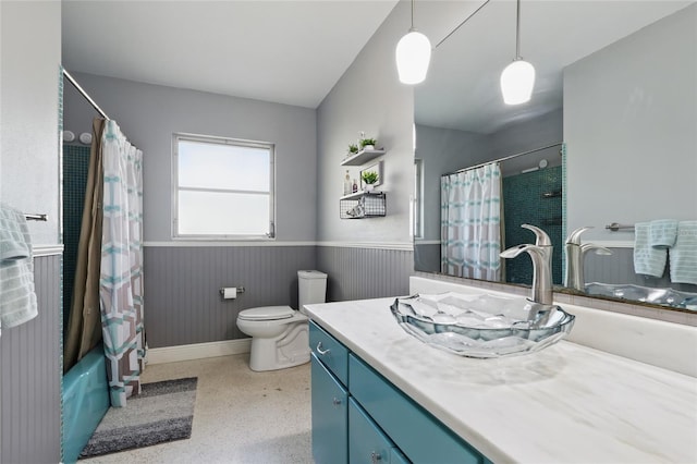 full bathroom with vanity, toilet, speckled floor, a wainscoted wall, and shower / tub combo
