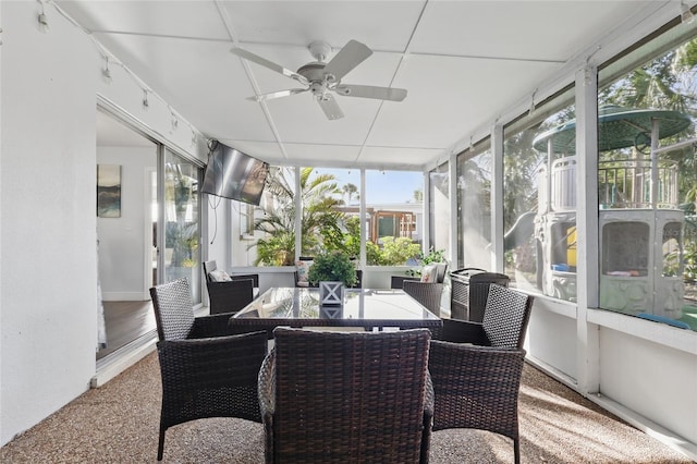 sunroom with outdoor dining space, ceiling fan, and a wealth of natural light