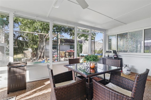 sunroom / solarium featuring a ceiling fan and outdoor dining space
