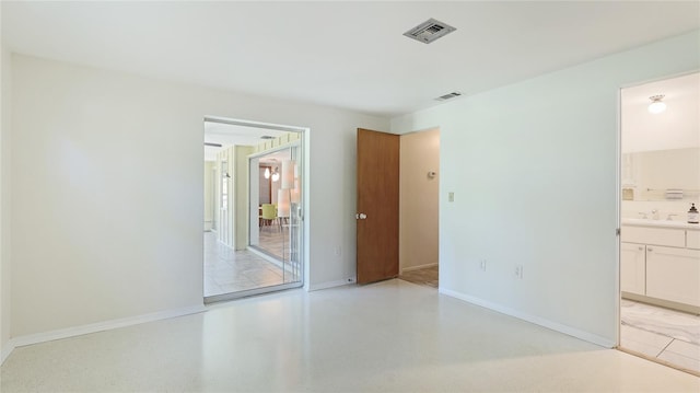 6529 Seagate Ave, Sarasota, FL 34231 - unfurnished bedroom featuring a sink, baseboards, and ensuite bathroom