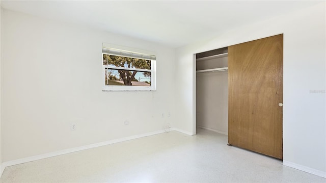 6529 Seagate Ave, Sarasota, FL 34231 - unfurnished bedroom with a closet, baseboards, and dark aggregate flooring