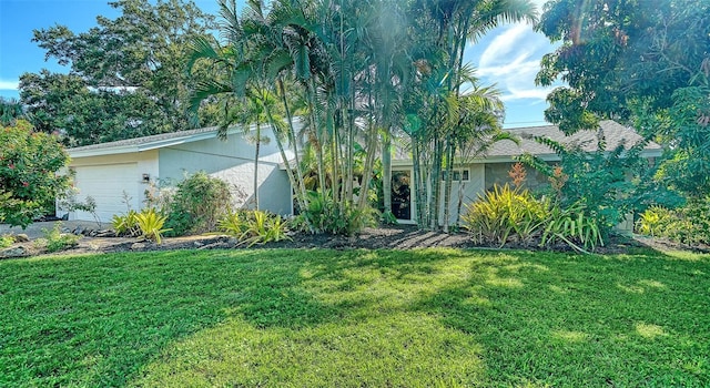 3761 Countryside Rd, Sarasota, FL 34233 - view of property hidden behind natural elements with stucco siding, an attached garage, and a front lawn