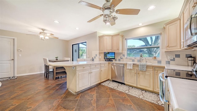 3761 Countryside Rd, Sarasota, FL 34233 - kitchen featuring appliances with stainless steel finishes, a ceiling fan, recessed lighting, a peninsula, and tasteful backsplash