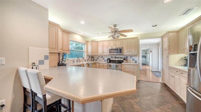 3761 Countryside Rd, Sarasota, FL 34233 - kitchen with a breakfast bar area, a ceiling fan, visible vents, appliances with stainless steel finishes, and a peninsula