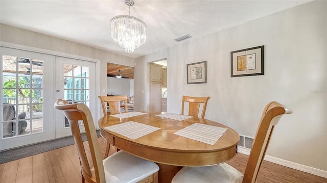 3761 Countryside Rd, Sarasota, FL 34233 - dining area featuring visible vents, baseboards, light wood-type flooring, french doors, and a notable chandelier