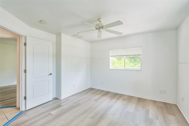 empty room with baseboards, ceiling fan, and light wood-style flooring