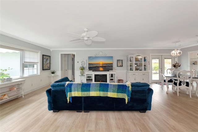 1722 Hazelwood St, Sarasota, FL 34231 - living area with light wood-type flooring, ornamental molding, a ceiling fan, and a warm lit fireplace