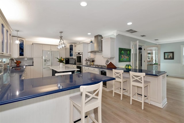 1722 Hazelwood St, Sarasota, FL 34231 - kitchen with white refrigerator with ice dispenser, wall chimney range hood, a peninsula, a sink, and ornamental molding