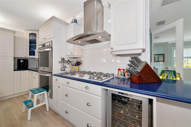 1722 Hazelwood St, Sarasota, FL 34231 - kitchen featuring range hood, double oven, white gas stovetop, beverage cooler, and dark countertops
