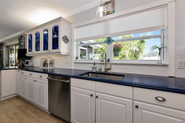 1722 Hazelwood St, Sarasota, FL 34231 - kitchen with a sink, stainless steel dishwasher, dark countertops, glass insert cabinets, and tasteful backsplash