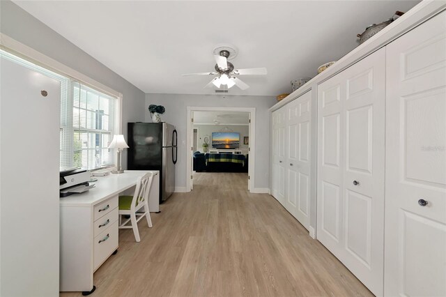 1722 Hazelwood St, Sarasota, FL 34231 - hallway with light wood-style flooring, a desk, and baseboards