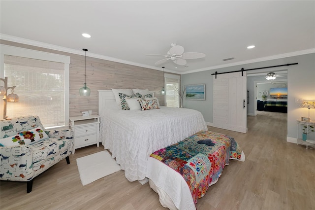 1722 Hazelwood St, Sarasota, FL 34231 - bedroom with a barn door, ornamental molding, wood finished floors, baseboards, and recessed lighting