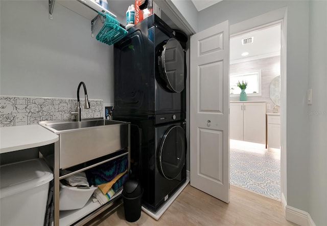 1722 Hazelwood St, Sarasota, FL 34231 - laundry area with stacked washer / drying machine and light wood-style floors