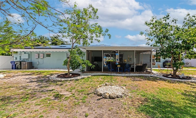 1722 Hazelwood St, Sarasota, FL 34231 - rear view of house featuring a sunroom, a lawn, and central AC unit