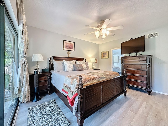 bedroom with ceiling fan, baseboards, light wood-type flooring, and visible vents