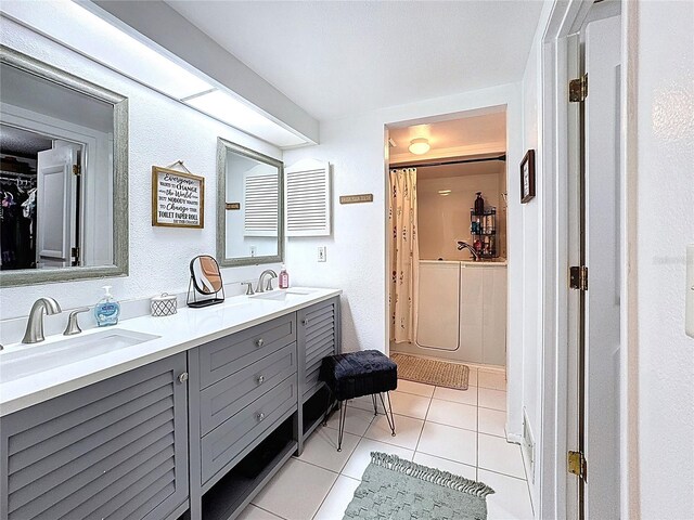 bathroom featuring a shower with curtain, tile patterned flooring, double vanity, and a sink