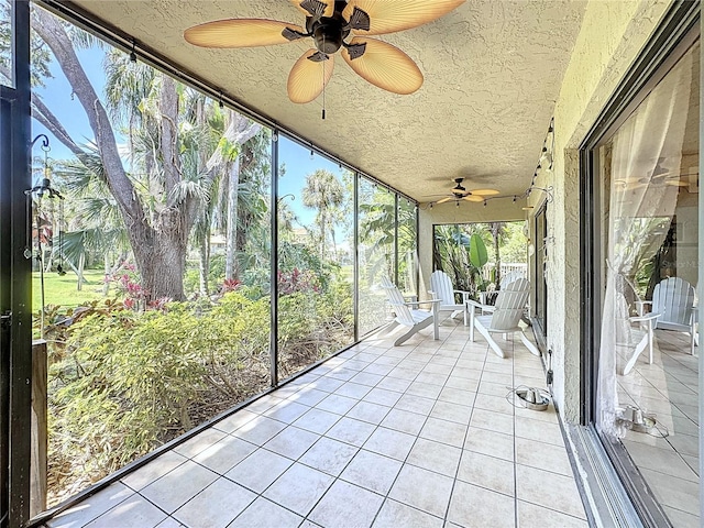unfurnished sunroom with a ceiling fan and a wealth of natural light