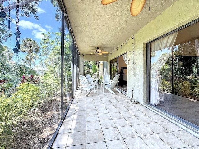 unfurnished sunroom featuring ceiling fan