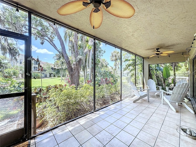 unfurnished sunroom featuring ceiling fan