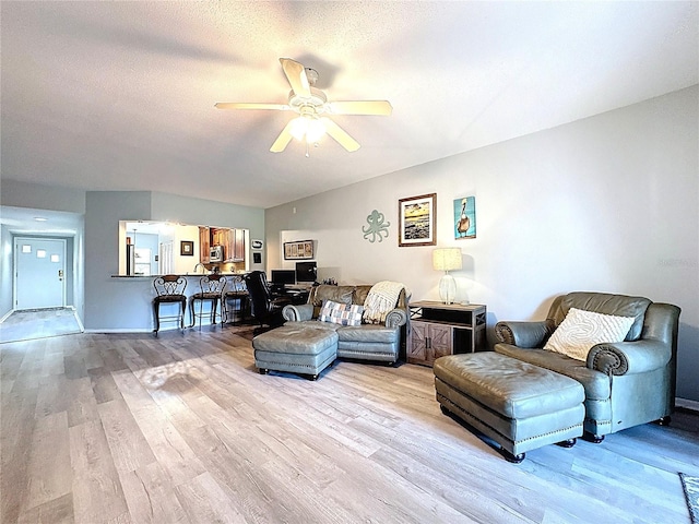 living room with ceiling fan and light wood-type flooring
