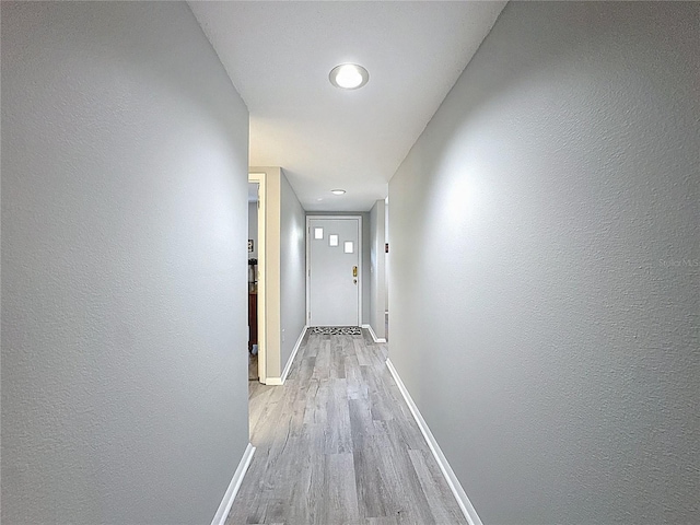 corridor featuring recessed lighting, baseboards, and light wood-style floors
