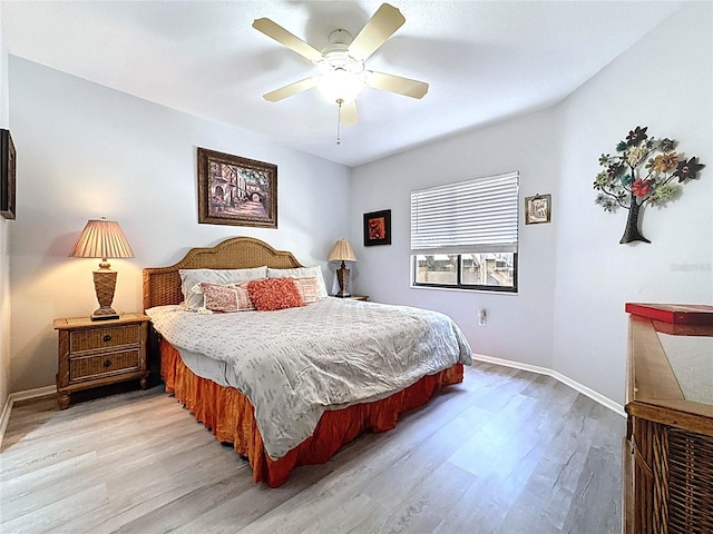 bedroom featuring light wood finished floors, baseboards, and ceiling fan