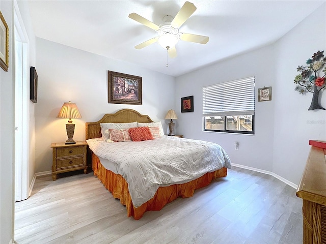 bedroom featuring light wood finished floors, baseboards, and ceiling fan