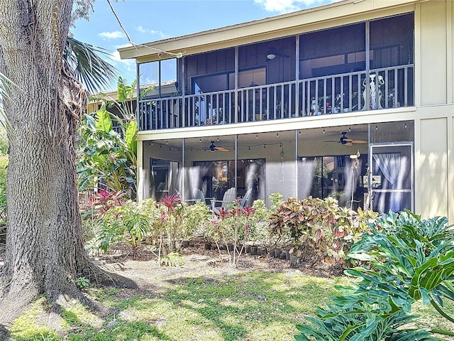 rear view of property with a sunroom and ceiling fan