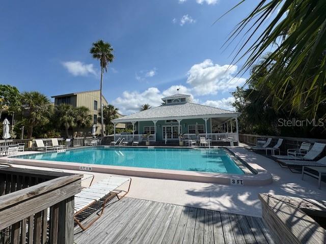 community pool featuring a patio area and a wooden deck