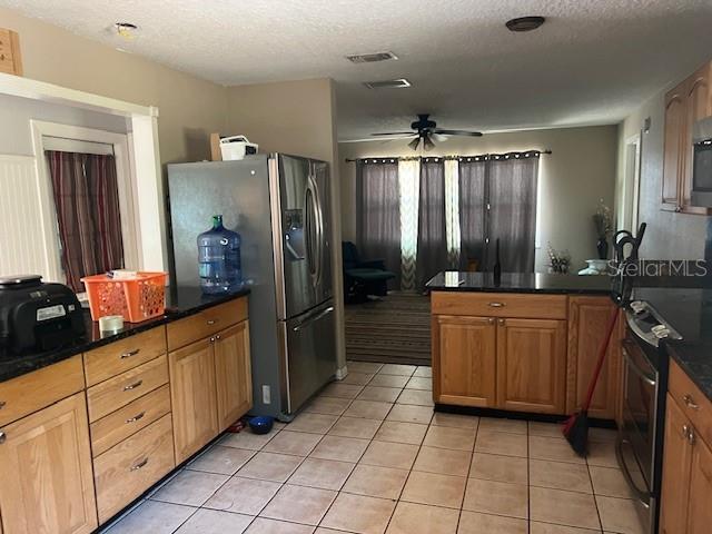 6383 N Jade Ter, Crystal River, FL 34428 - kitchen with stainless steel appliances, a ceiling fan, light tile patterned floors, and a peninsula
