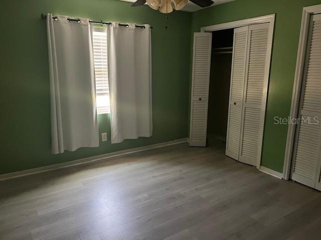 6383 N Jade Ter, Crystal River, FL 34428 - unfurnished bedroom with baseboards, wood finished floors, and multiple windows