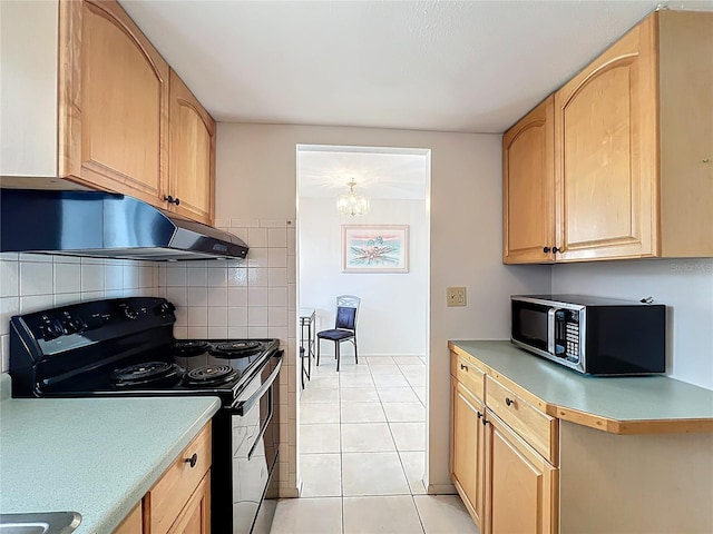 2321 Canal Dr Unit F25, Bradenton, FL 34207 - kitchen featuring black range with electric cooktop, under cabinet range hood, light countertops, decorative backsplash, and light tile patterned flooring