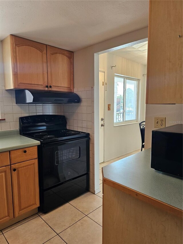 2321 Canal Dr Unit F25, Bradenton, FL 34207 - kitchen featuring black appliances, extractor fan, light tile patterned floors, light countertops, and a textured ceiling