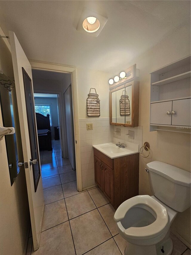 2321 Canal Dr Unit F25, Bradenton, FL 34207 - bathroom with vanity, toilet, tile walls, and tile patterned floors