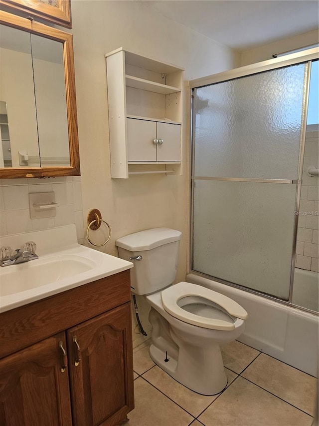 2321 Canal Dr Unit F25, Bradenton, FL 34207 - bathroom with toilet, vanity, tile patterned floors, enclosed tub / shower combo, and decorative backsplash