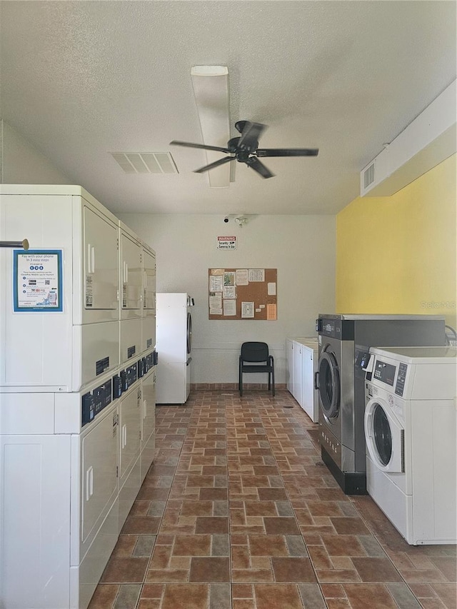 2321 Canal Dr Unit F25, Bradenton, FL 34207 - communal laundry room featuring stacked washer / drying machine, washing machine and dryer, a ceiling fan, baseboards, and a textured ceiling