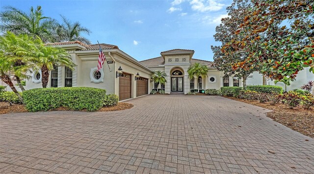 6919 Dominion Ln, Lakewood Ranch, FL 34202 - mediterranean / spanish home featuring a garage, stucco siding, and decorative driveway