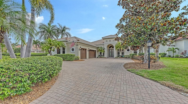 6919 Dominion Ln, Lakewood Ranch, FL 34202 - mediterranean / spanish-style home featuring a garage, decorative driveway, stucco siding, and a front yard