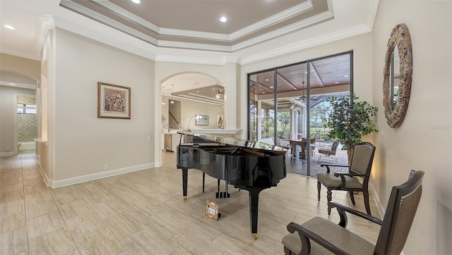 6919 Dominion Ln, Lakewood Ranch, FL 34202 - sitting room featuring arched walkways, a tray ceiling, plenty of natural light, crown molding, and recessed lighting