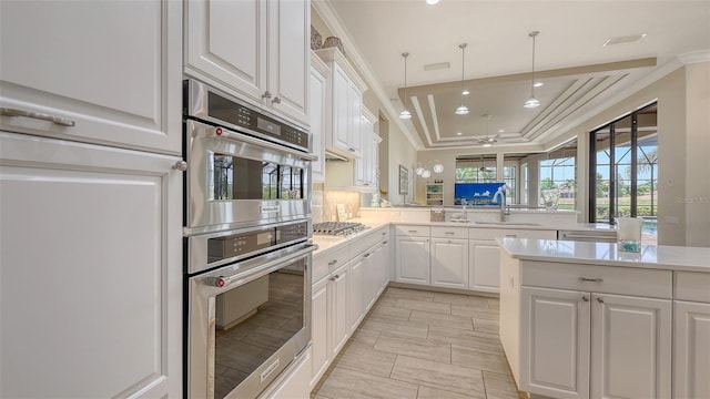 6919 Dominion Ln, Lakewood Ranch, FL 34202 - kitchen with a tray ceiling, light countertops, ceiling fan, white cabinetry, and stainless steel gas cooktop