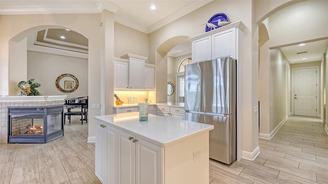 6919 Dominion Ln, Lakewood Ranch, FL 34202 - kitchen featuring freestanding refrigerator, white cabinets, a center island, ornamental molding, and wood finish floors