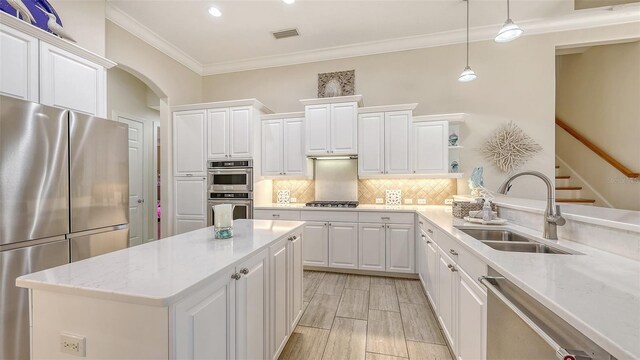 6919 Dominion Ln, Lakewood Ranch, FL 34202 - kitchen with stainless steel appliances, open shelves, ornamental molding, white cabinetry, and recessed lighting