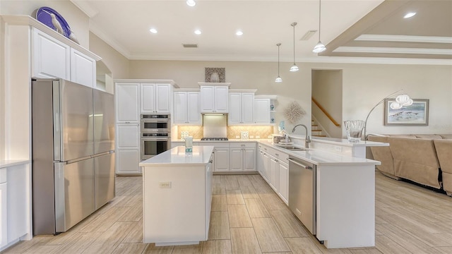 6919 Dominion Ln, Lakewood Ranch, FL 34202 - kitchen featuring appliances with stainless steel finishes, ornamental molding, a peninsula, open floor plan, and white cabinets