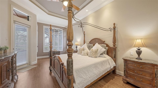 6919 Dominion Ln, Lakewood Ranch, FL 34202 - bedroom featuring light wood finished floors, a tray ceiling, ornamental molding, access to exterior, and ceiling fan